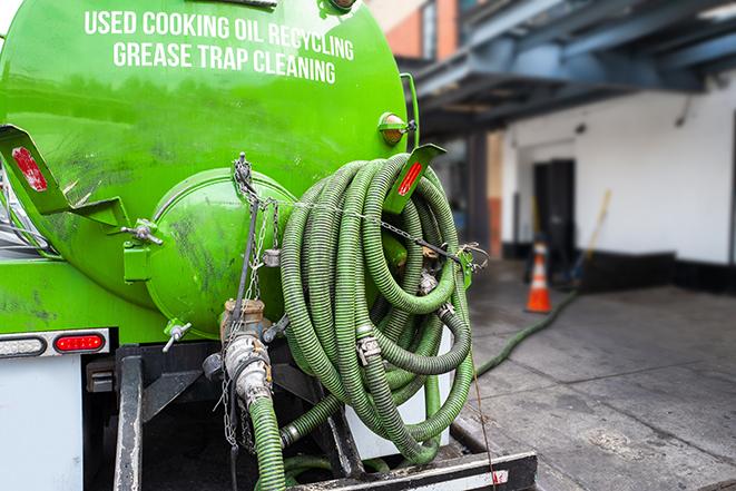 grease trap pumping truck servicing a restaurant in Attica